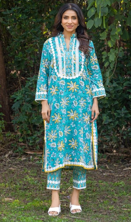 Woman models a floral kurta and pants outdoors.