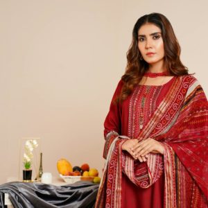 South Asian woman in red traditional garment, standing indoors, fashion photography.