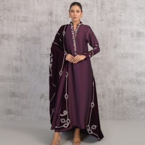 A woman in a purple dress standing in front of a wall