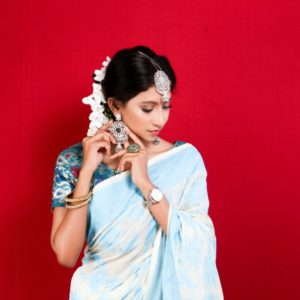 woman in blue dress wearing white floral headdress