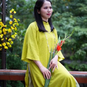 a woman in a yellow dress holding a bouquet of flowers